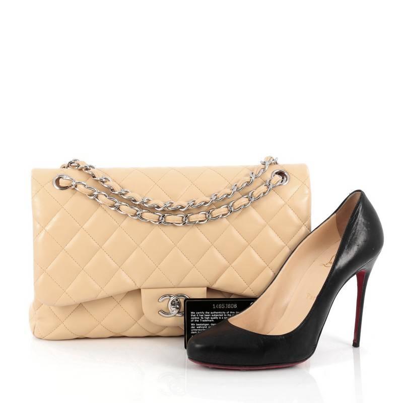 This authentic Chanel Classic Double Flap Bag Quilted Lambskin Jumbo exudes a classic yet easy style made for the modern woman. Crafted from nude lambskin leather, this elegant flap features Chanel's signature diamond quilted design, woven-in