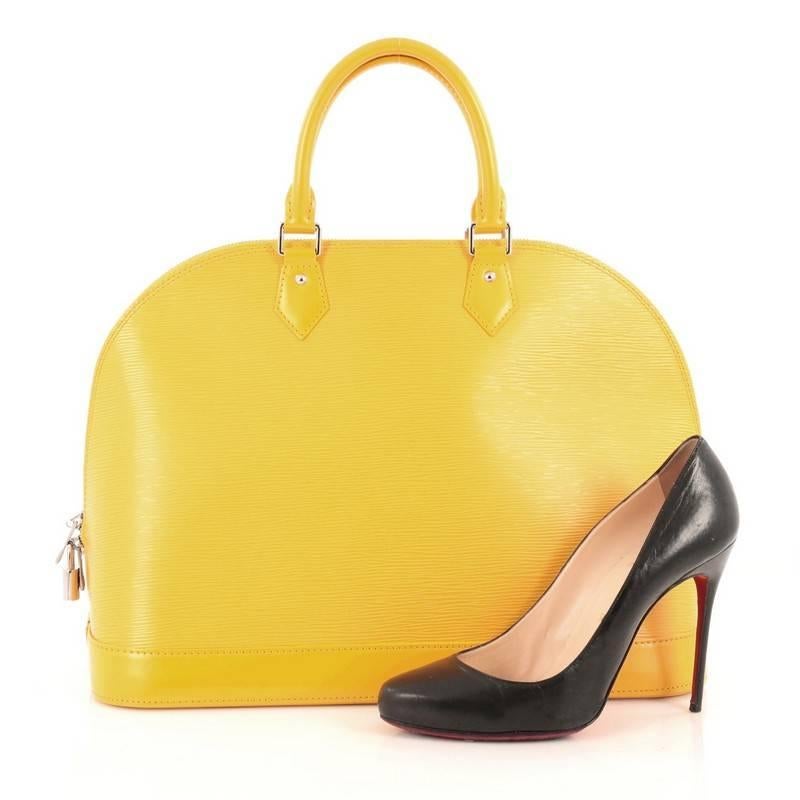 This authentic Louis Vuitton Alma Handbag Epi Leather MM is elegant and as classic as they come. Constructed with Louis Vuitton's signature tassil yellow epi leather, this bag features a structured and dome-like silhouette, dual-rolled leather
