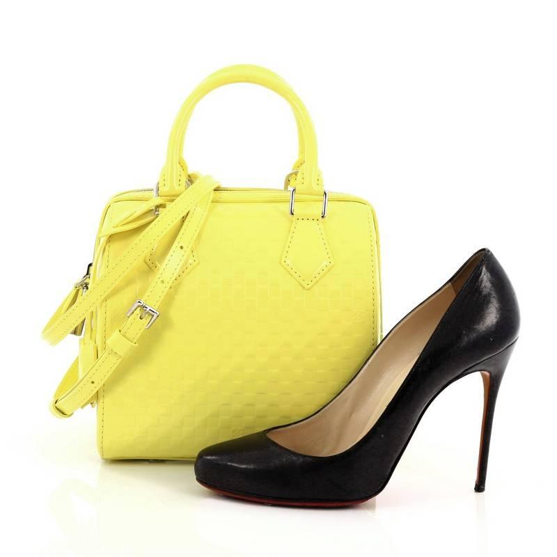 This authentic Louis Vuitton Speedy Cube Bag Facette PM presented in the brand's Spring/Summer 2013 Collection is a limited edition piece showcasing the brand's classic speedy design with an edgy style. Crafted from yellow damier facette, this