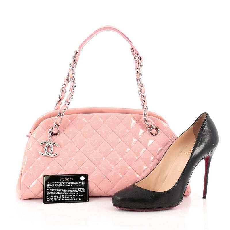 This authentic Chanel Just Mademoiselle Handbag Quilted Patent Medium showcases a sleek style that complements any look. Crafted from pink patent leather in Chanel's iconic diamond quilt pattern, this bag features woven-in leather chain straps with