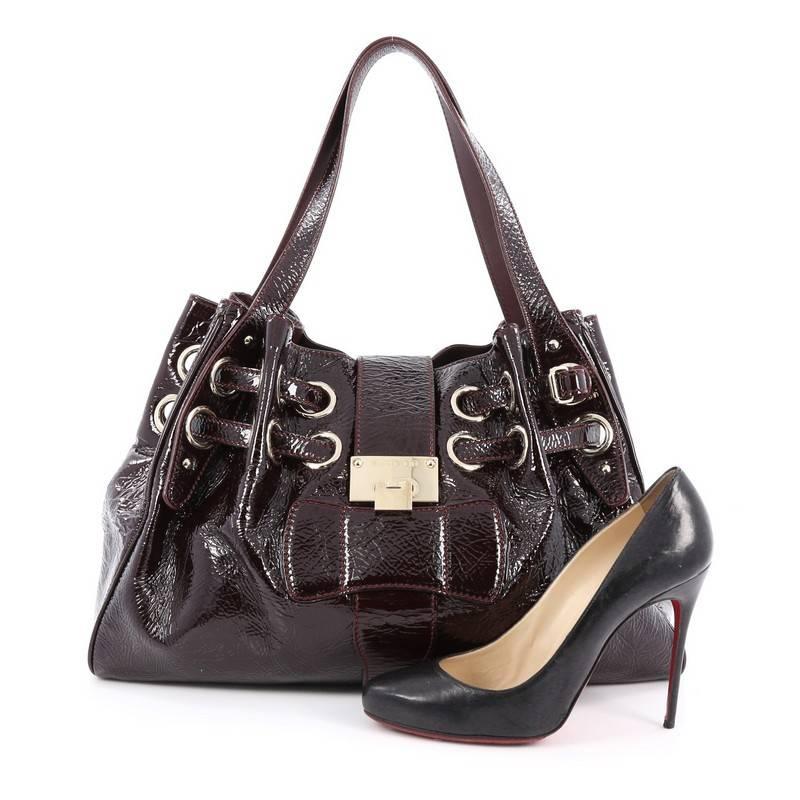 This authentic Jimmy Choo Riki Hobo Patent showcases a stylish bag perfect for the modern woman. Crafted in maroon patent leather, this eye-catching tote features tall dual flat leather handles, softly pleated dual drawstring at top allowing the bag