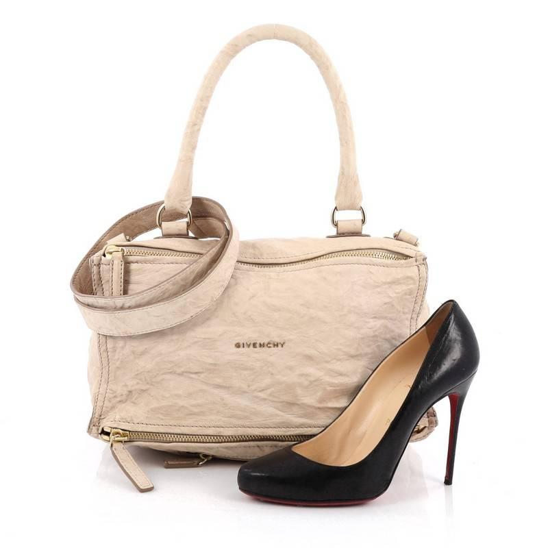 This authentic Givenchy Pandora Bag Distressed Leather Medium is the perfect companion for any on-the-go fashionista. Crafted in beige distressed leather, this edgy and cult-favorite satchel features a pandora box-inspired silhouette, a singular top