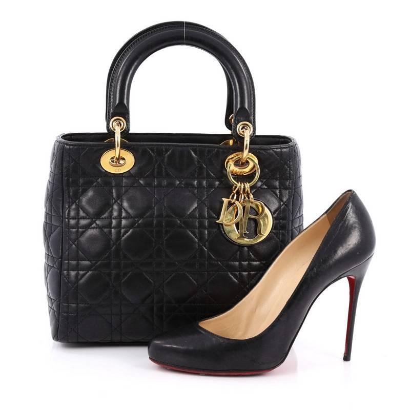 This authentic Christian Dior Lady Dior Handbag Cannage Quilt Lambskin Medium is an elegant classic bag that every fashionista needs in her wardrobe. Crafted from black lambskin leather in Dior's iconic cannage quilting, this boxy bag features short
