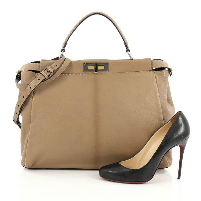 This authentic Fendi Peekaboo Handbag Leather Large is one of Fendi's best known designs exuding a luxurious yet minimalist appearance. Crafted in light brown leather, this versatile and stylish satchel features a flat leather top handle, protective