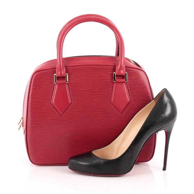 This authentic Louis Vuitton Sablons Handbag Epi Leather is classic and sophisticated in design ideal for everyday use. Crafted in rubis red epi leather, this boxy, structured bag features dual-rolled handles, subtle LV logo at the front and