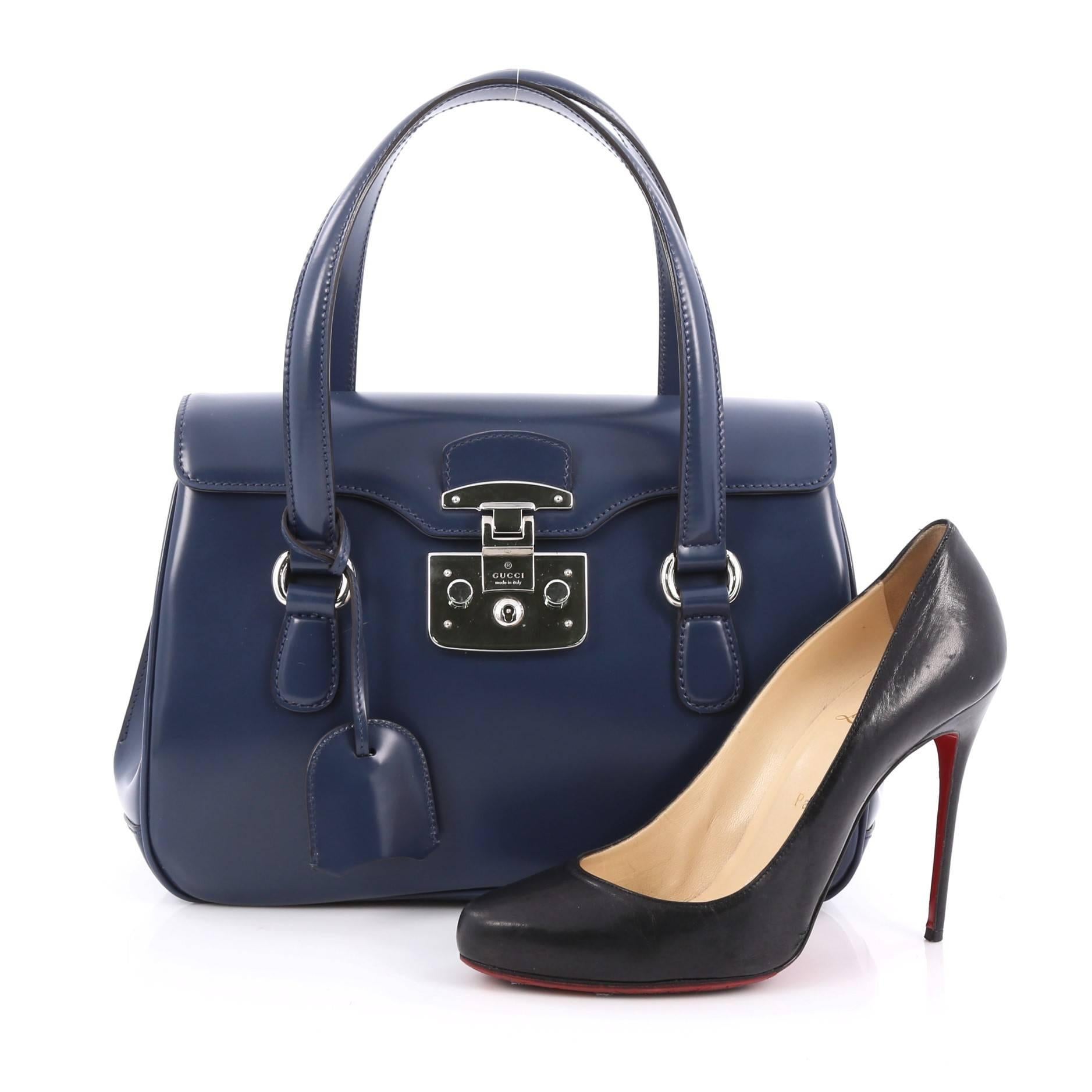 This authentic Gucci Lady Lock Satchel Leather Small is the perfect small accessory for work. Crafted in smooth and shiny blue leather, this satchel features dual-flat leather handles, retro-style lady lock closure, frontal flap, and silver-tone