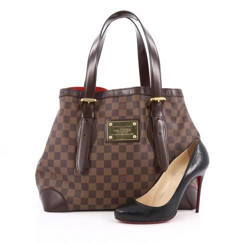 This authentic Louis Vuitton Hampstead Handbag Damier MM is the ultimate luxurious tote that showcases modern structure. Crafted from the brand’s damier ebene coated canvas, this tote features dual tall flat leather handles with buckle details,