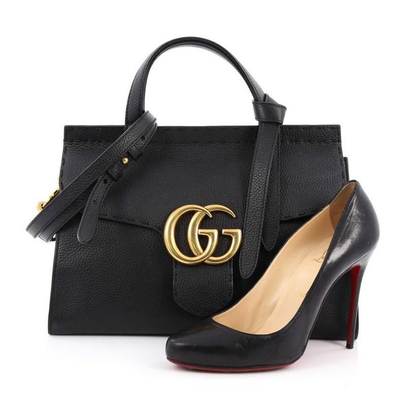 This authentic Gucci Marmont Top Handle Bag Leather Small presented in the brand's 2016 Collection balances understated versatility with glamorous flair. Crafted from black leather, this stylish bag features dual-flat handles with knot on one end,