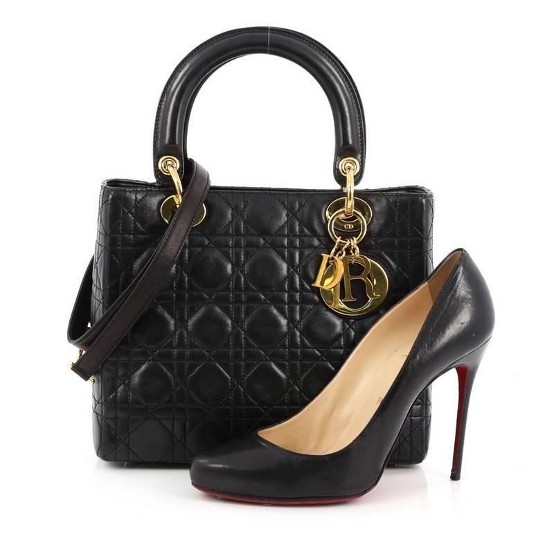 This authentic Christian Dior Lady Dior Handbag Cannage Quilt Lambskin Medium is a classic staple that every fashionista needs in her wardrobe. Crafted from black lambskin leather in Dior's iconic cannage quilting, this boxy tote features dual short