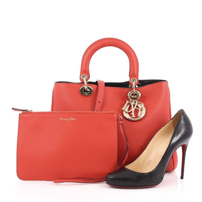 This authentic Christian Dior Diorissimo Tote Pebbled Leather Medium is an elegant, classic statement piece that every fashionista needs in her wardrobe. Crafted from red leather, this chic tote features smooth short dual handles with sleek Dior