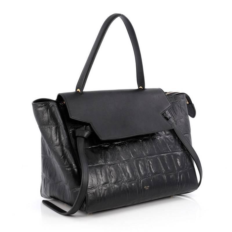 This authentic Celine Belt Bag Crocodile Embossed Leather Medium is sure to make a statement. Crafted from sleek black crocodile embossed leather, this bold and beautiful bag features a looped top handle, expanded wings, top flap slide closure,