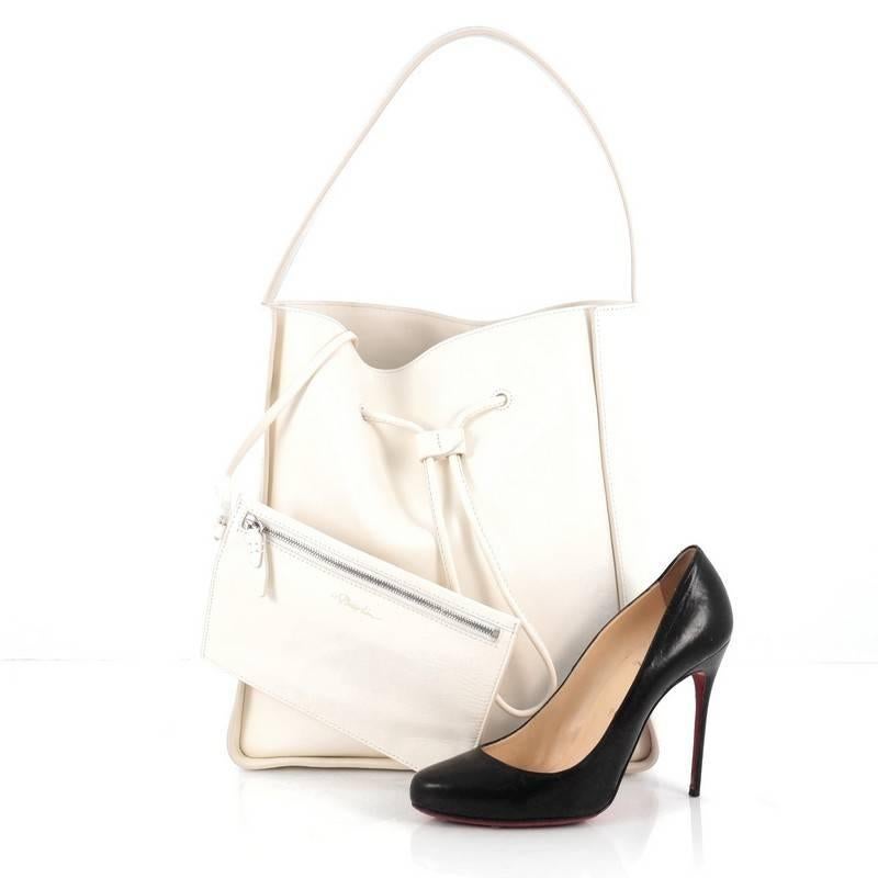This authentic 3.1 Phillip Lim Soleil Bucket Bag Leather Large is an architectural bucket bag defined by its clean lined design that's perfect for your everyday looks. Crafted from white leather, this bag features flat leather handle, structured