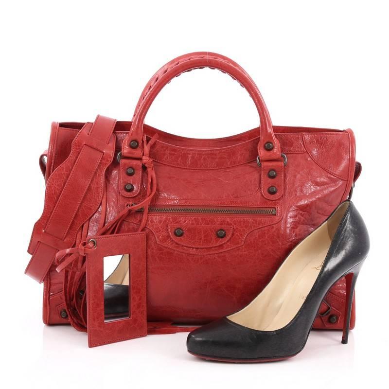 This authentic Balenciaga City Classic Studs Handbag Leather Medium is for the on-the-go fashionista. Constructed in red leather, this popular bag features dual braided woven handle straps, front zip pocket, iconic Balenciaga classic studs and