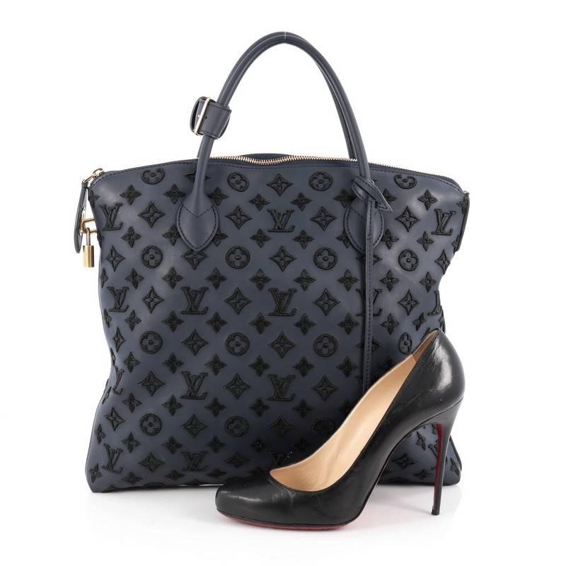 This authentic Louis Vuitton Lockit Handbag Limited Edition Monogram Addiction Rubber Vertical presented in Fall/Winter 2011-2012 collection is unusual and exotic in design. Crafted in blue synthetic rubber, this unique bag is embroidered with lamé