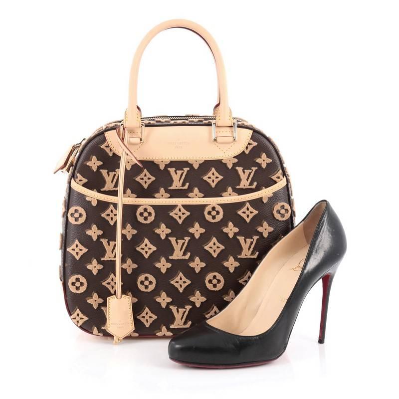 This authentic Louis Vuitton Deauville Cube Bag Limited Edition Monogram Canvas Tuffetage from the Pre-Fall 2013 season is a modern and unique twist on a timeless luxury brand. Constructed of classic Louis Vuitton brown monogram canvas with with