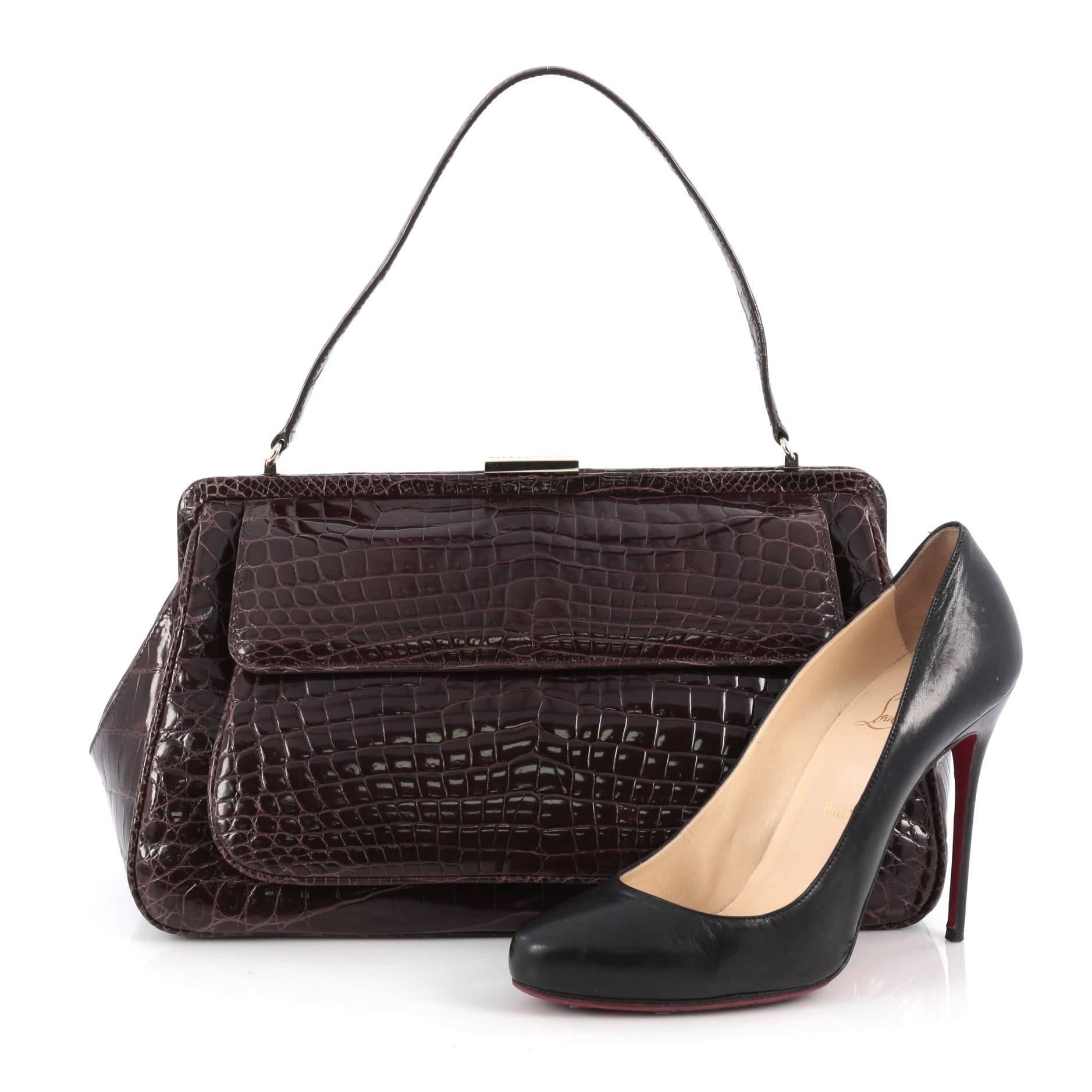 This authentic Tiffany & Co. Laurelton Handbag Crocodile is a chic and sophisticated bag perfect for everyday looks and night outs. Crafted from genuine brown crocodile skin, this luxurious, exotic bag features a single flat handle, exterior pocket