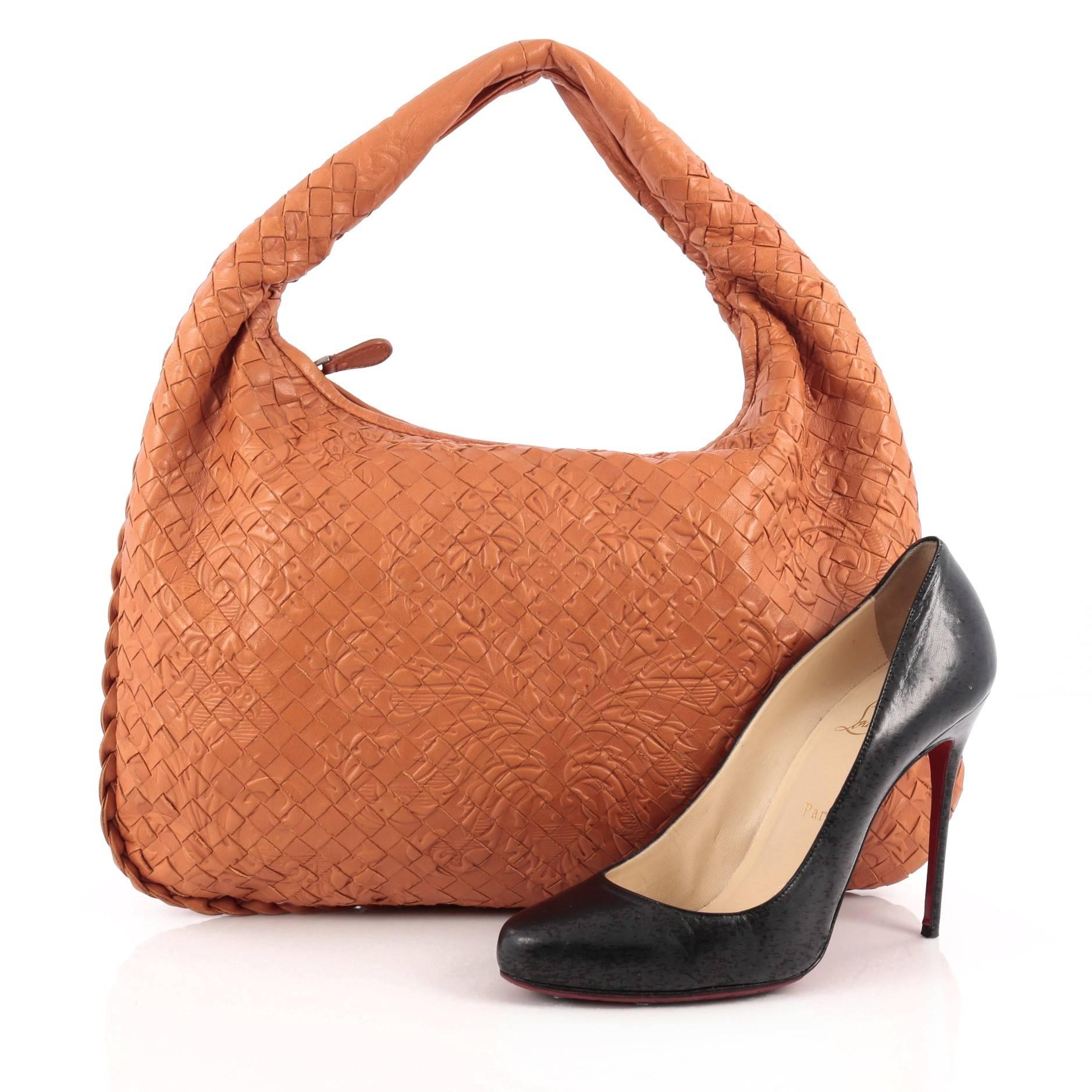 This authentic Bottega Veneta Veneta Hobo Embossed Intrecciato Nappa Medium is a timelessly elegant bag with a casual silhouette. Excellently crafted from orange nappa leather woven in Bottega Veneta's signature intrecciato method with a subtle