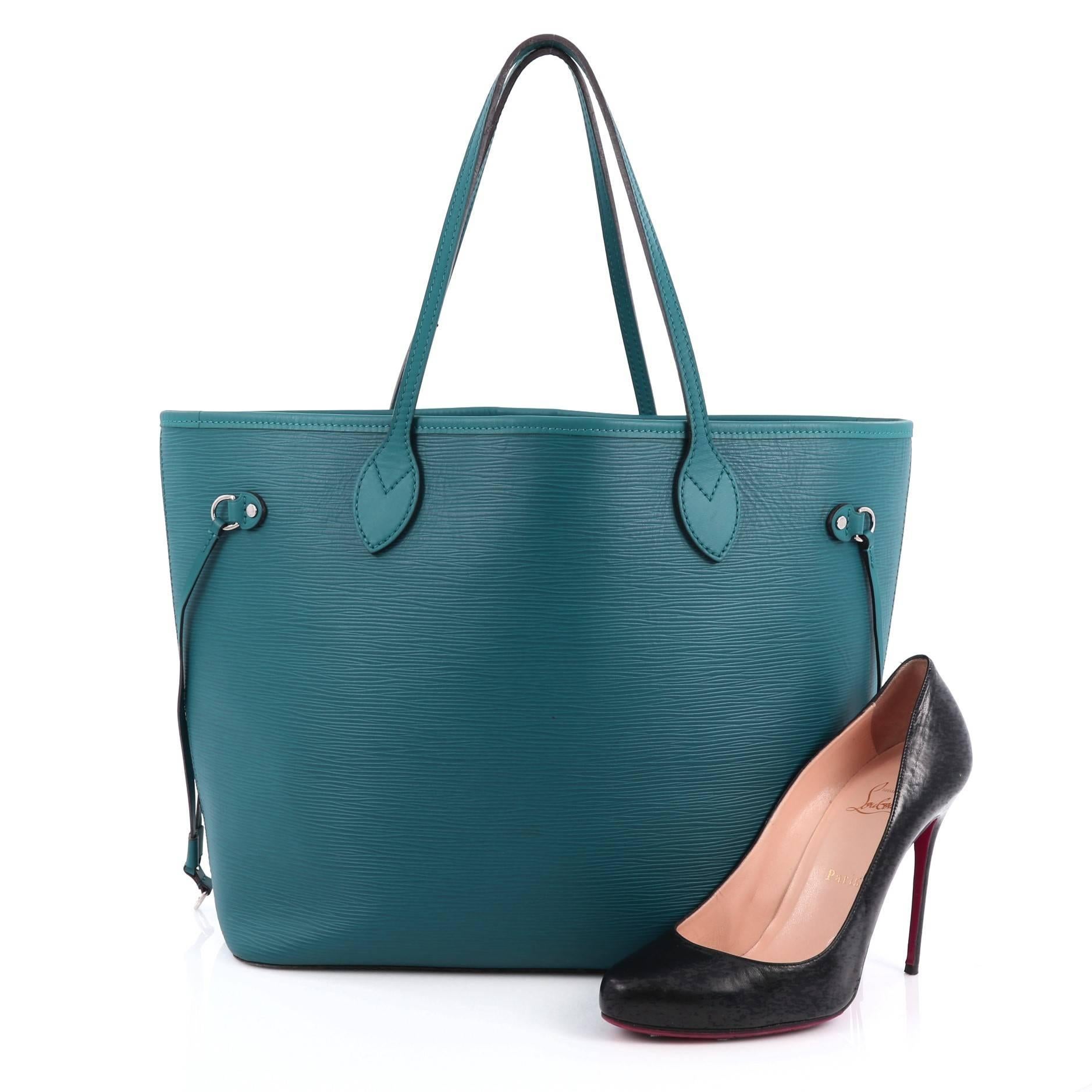 This authentic Louis Vuitton Neverfull Tote Epi Leather MM is a perfect companion for daily excursions. Crafted in teal epi leather, this iconic, easy-to-carry tote features dual flat leather handles, side tassels that cinches and expands and
