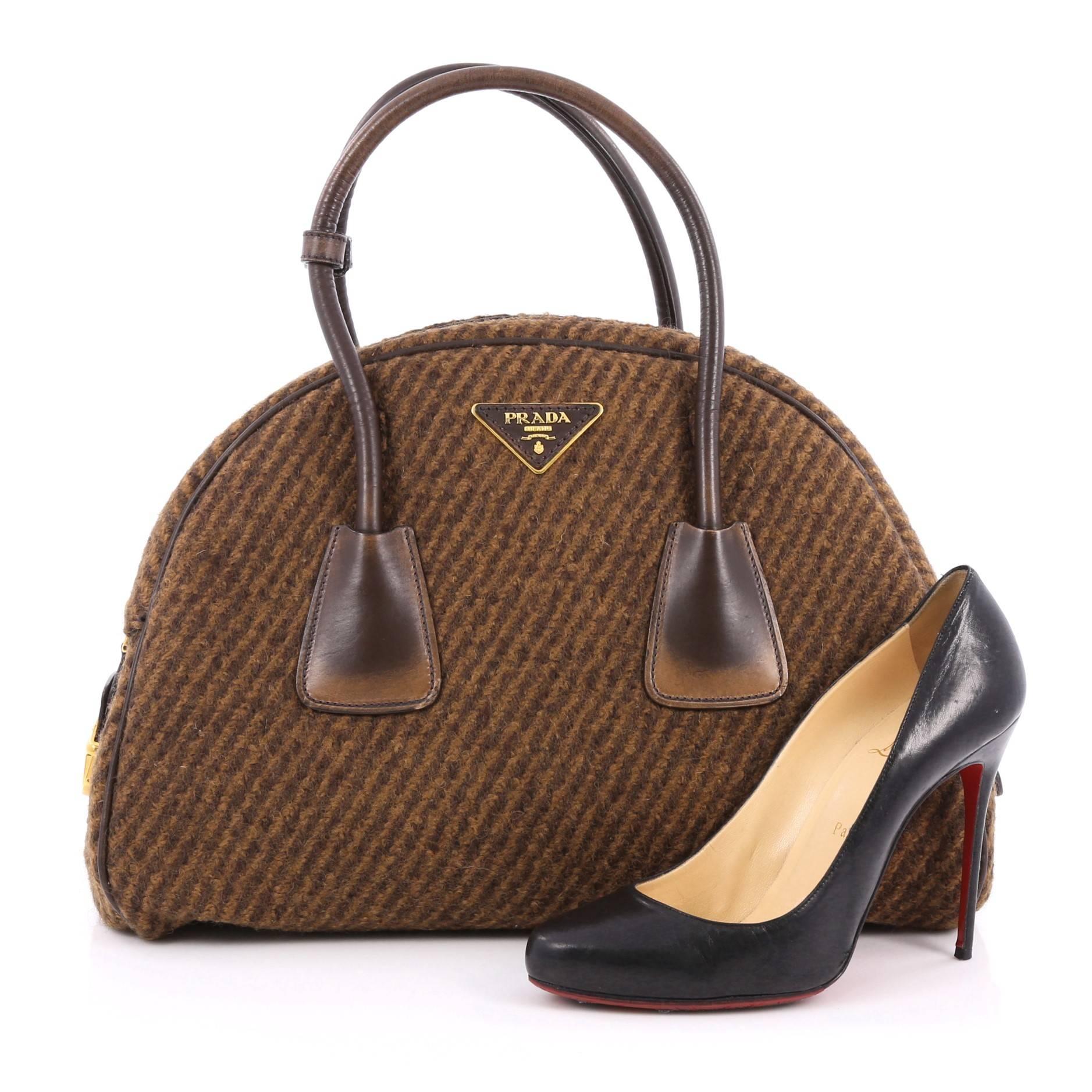 This authentic Prada Vichy Vintage Bowler Bag Tweed Large presented in the brand's Fall 2013 Collection is an elegant, eye-catching accessory made for every fashionista. Crafted from brown tweed, this chic bag features stained dual-rolled handles,