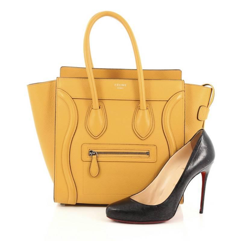 This authentic Celine Luggage Handbag Grainy Leather Micro is one of the most sought-after bags beloved by fashionistas. Crafted from mustard yellow grainy leather, this minimalist tote features dual-rolled handles, an exterior front pocket,