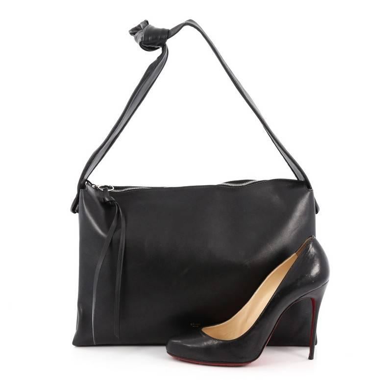 This authentic Celine Knotted Shoulder Bag Leather is a stunning in its simplicity and beauty. Crafted from black leather, this bag features leather asymmetrical shoulder straps that are knotted just to one side and silver-tone hardware accents. Its