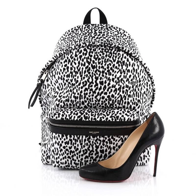 This authentic Saint Laurent City Backpack Printed Canvas is an eye catching and luxurious style made for on-the-go fashionistas. Crafted from black and white baby cat printed canvas, this unique bag features, adjustable padded strap, exterior front
