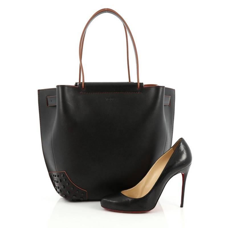 This authentic Tod's Wave Tote Leather Medium is classic and sophisticated in design perfect for everyday look. Crafted in smooth black leather, this tote features dual-flat leather handles, multiple black bottom studs and silver-tone hardware