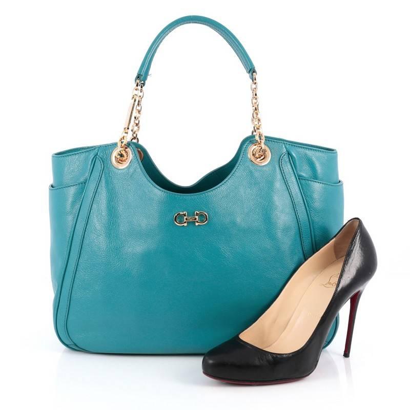 This authentic Salvatore Ferragamo Betulla Chain Tote Leather Medium is minimalist and classic in design, ideal for everyday use. Crafted from turquoise leather, this elegant tote features chain shoulder straps with leather pads, signature Salvatore