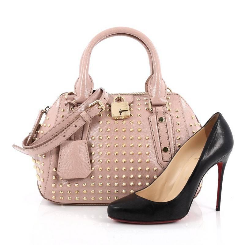 This authentic Burberry Blaze Bag Studded Saffiano Leather Small is a sleek and versatile bag that adds a rock star flair to your outfits. Crafted from light pink saffiano leather, this bag features dual-rolled leather handles, removable, adjustable