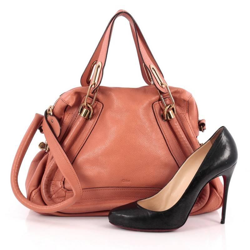 This authentic Chloe Paraty Top Handle Bag Leather Medium mixes everyday style and functionality perfect for the modern woman. Crafted from light peach leather, this versatile bag features dual flat handles, piped trim details, side twist locks, and