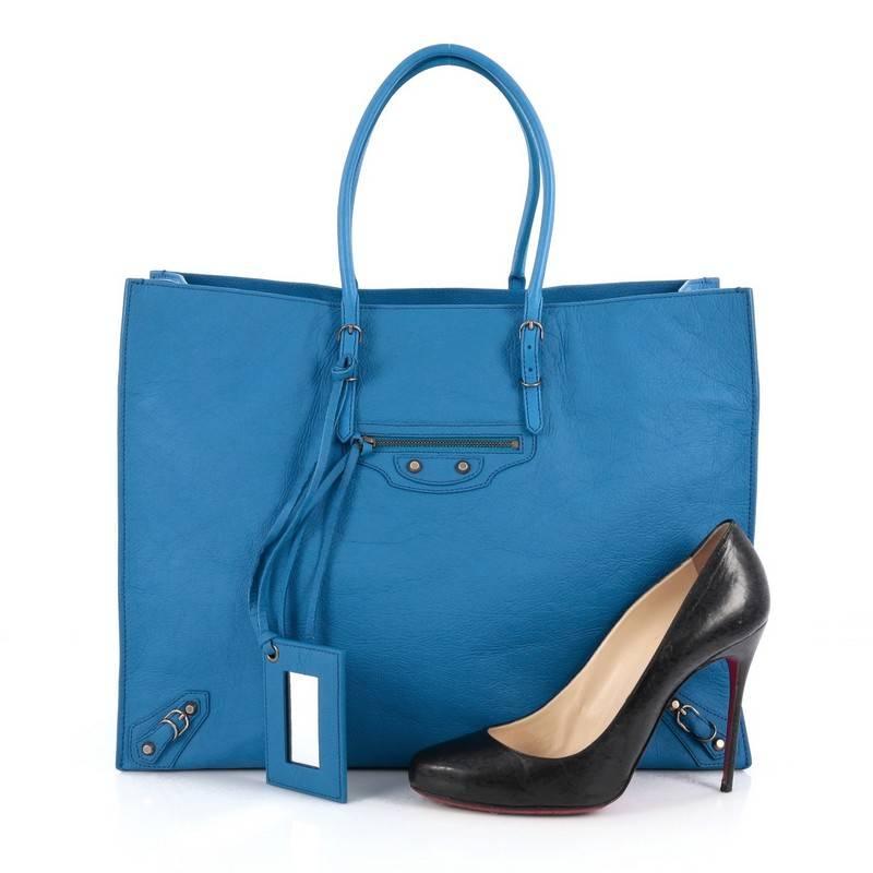 This authentic Balenciaga Papier A4 Classic Studs Handbag Leather Medium is a modern and minimalist accessory perfect for everyday excursions. Crafted in blue leather, this lightweight tote features slim handles, zip sides that allows the bag to