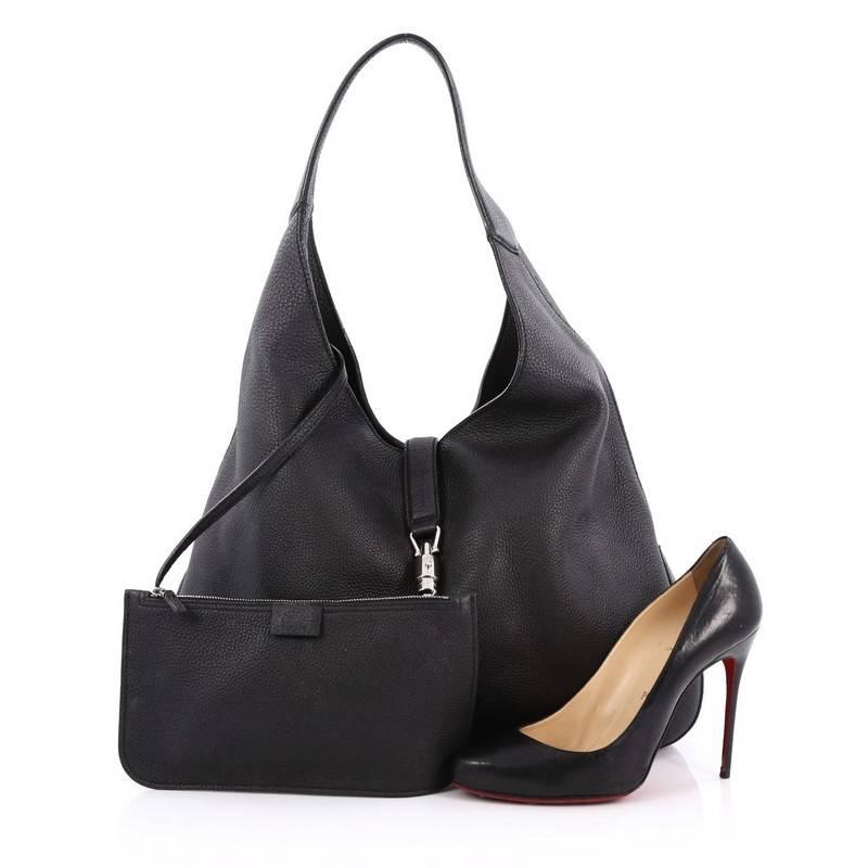 This authentic Gucci Jackie Hobo Soft Leather presented in the brand's Fall/Winter 2014 Collection is a modern and clean representation of its classic Jackie bag. Crafted from black leather, this luxurious, no-fuss hobo features a single loop