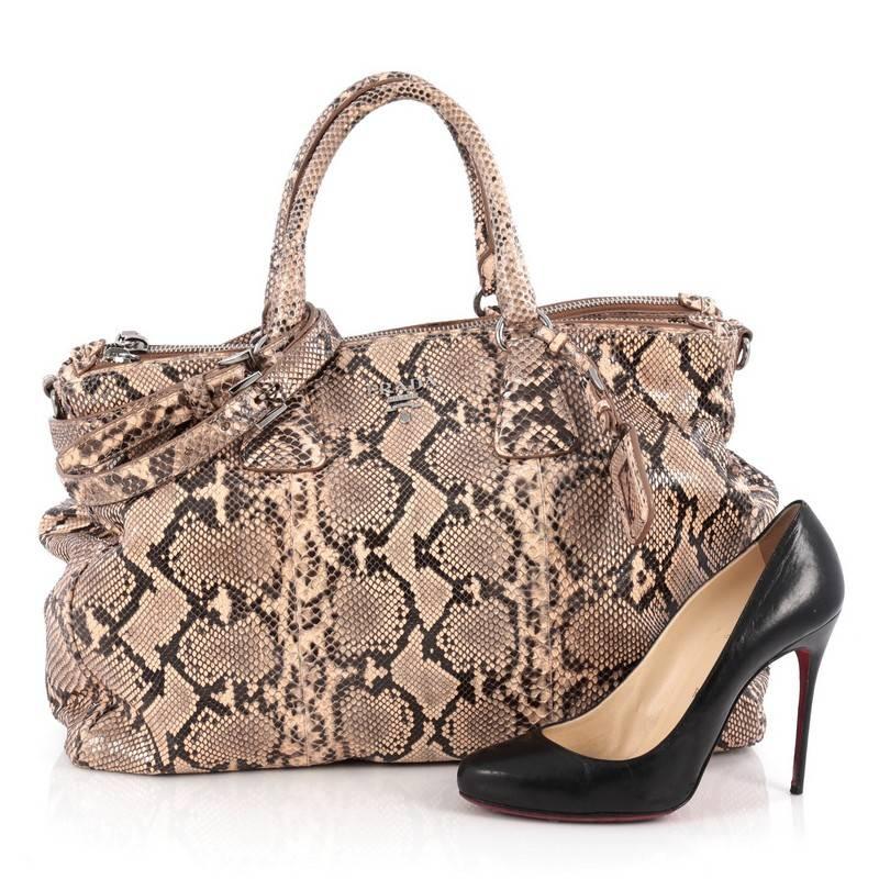 This authentic Prada Double Zip Lux Tote Python Large is the perfect bag to complete any outfit. Crafted from genuine nude python skin, this boxy tote features side snap buttons, raised Prada logo, dual-rolled handles and gunmetal-tone hardware