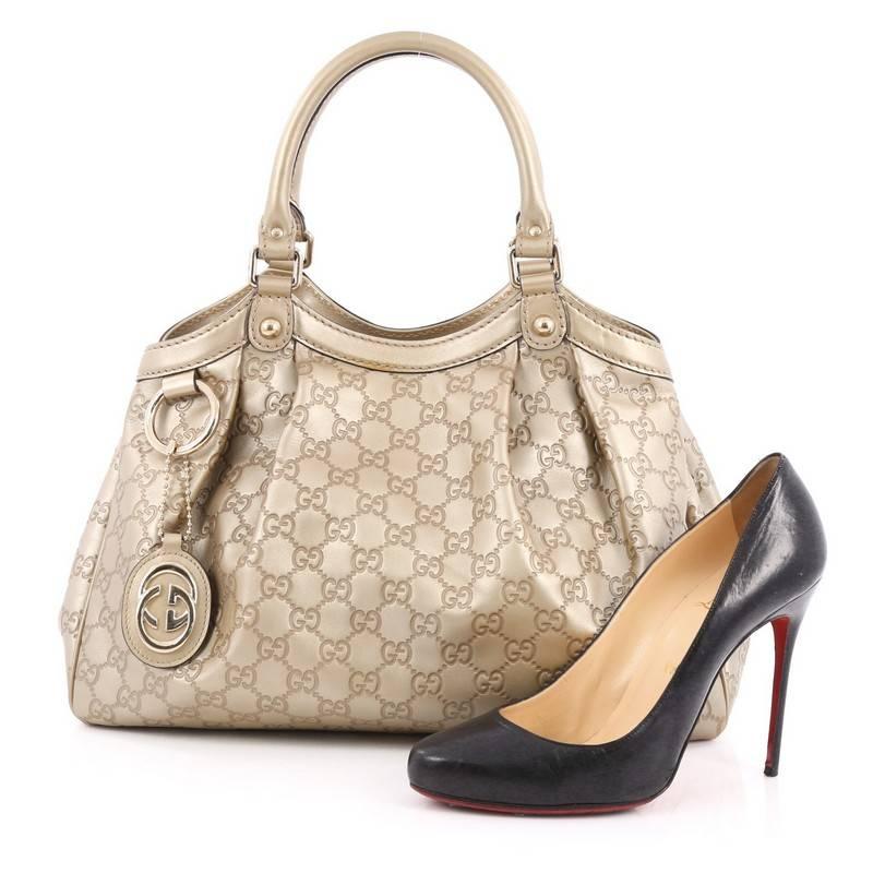 This authentic Gucci Sukey Tote Guccissima Leather Medium is a chic tote ideal for your everyday wear. Crafted from gold guccissima leather, this pleated tote with a ring charm accent features dual-rolled leather top handles, side snap buttons, and