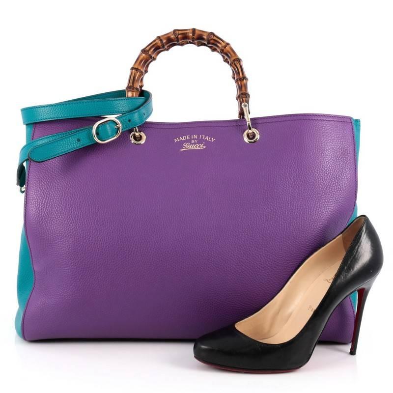 This authentic Gucci Bicolor Bamboo Shopper Tote Leather Large is a classic must-have. Crafted from purple and teal leather, this simple yet stylish tote features Gucci's signature sturdy bamboo handles, protective base studs, stamped logo at the