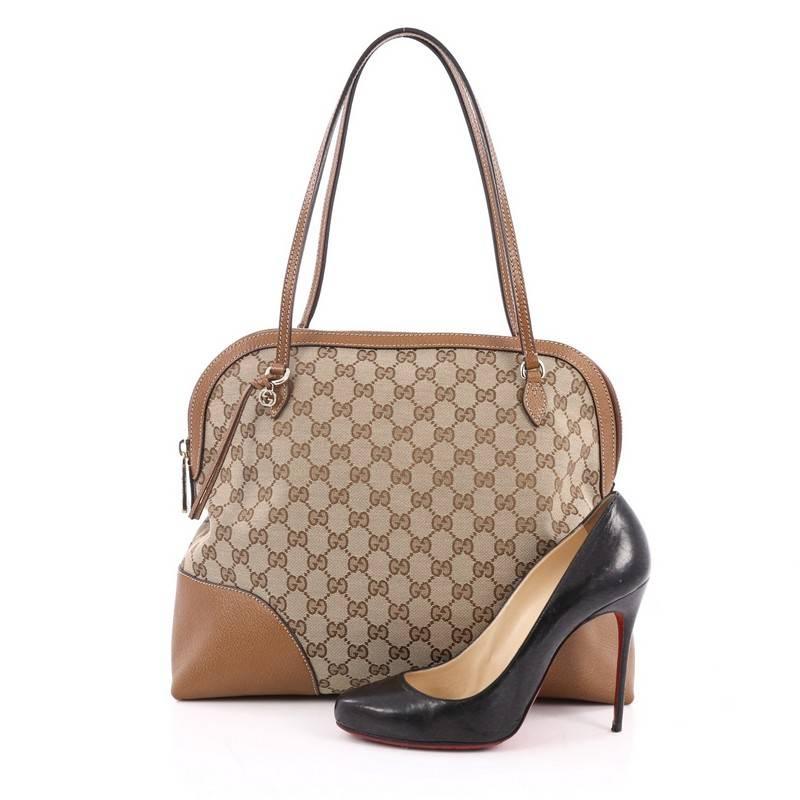 This authentic Gucci Bree Dome Tote GG Canvas Medium is perfect for everyday casual look. Crafted in brown GG canvas with brown leather trims, this dome-style tote features tall slim handles, and gold-tone hardware accents. Its top zip closure opens
