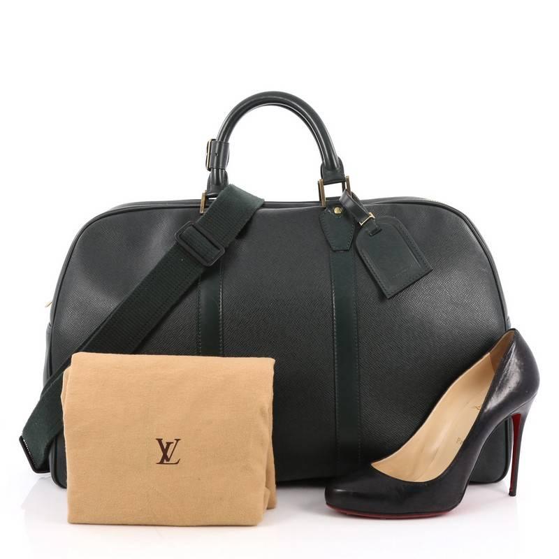 This authentic Louis Vuitton Kendall Handbag Taiga Leather PM features the brand's timeless travel bags. Constructed from forest green taiga leather, this travel-sized duffle features a simple, classic silhouette, dual-rolled leather handles, and