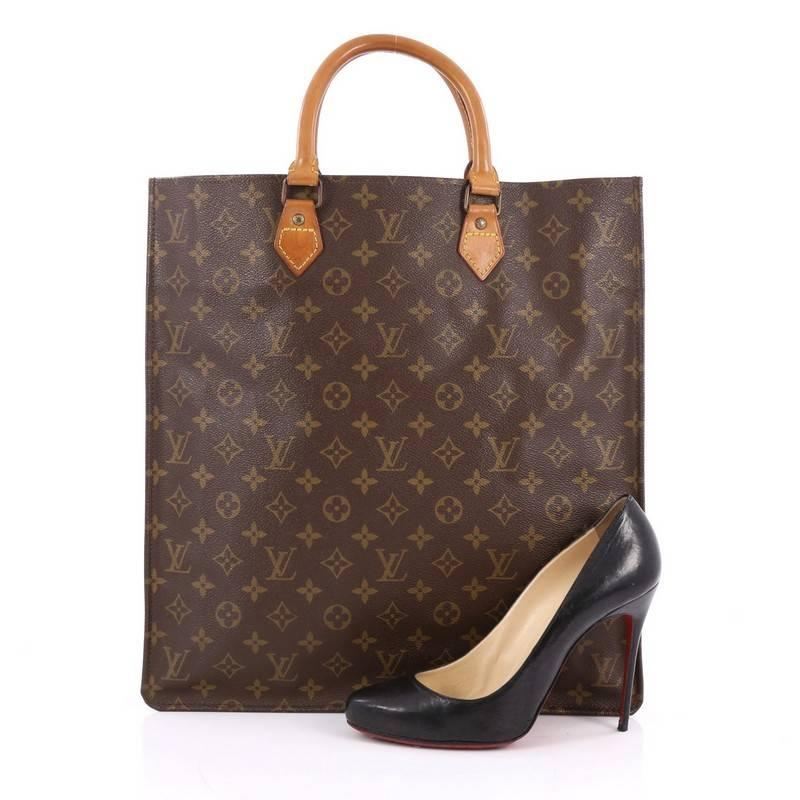 This authentic Louis Vuitton Sac Plat Handbag Monogram Canvas GM is a compact and structured design made for style-conscious professionals. Crafted in the brand's iconic monogram coated canvas, this simple shopper silhouette features dual-rolled