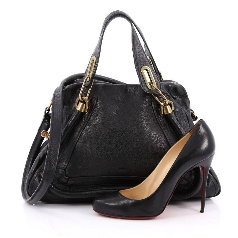 This authentic Chloe Paraty Top Handle Bag Leather Medium mixes everyday style and functionality perfect for the modern woman. Crafted from black leather, this versatile bag features dual flat handles, piped trim details, side twist locks, and aged