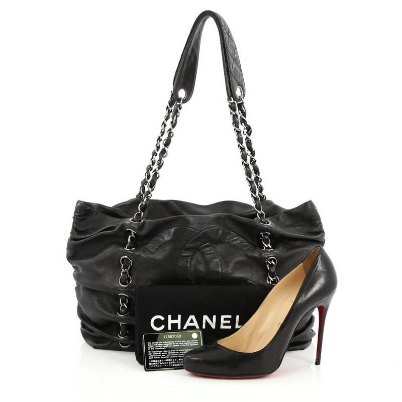 This authentic Chanel Timeless Sharpei Tote Lambskin Large is a stunning shoulder bag perfect for your daily excursions. Crafted from black lambskin leather, this luxurious bag features dual woven-in leather chain shoulder straps inserted through