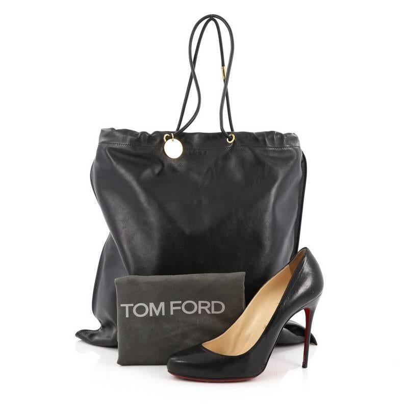 This authentic Tom Ford Medallion Flat Tote Leather Vertical is simple and classic in design ideal for everyday use. Crafted in black leather, this tote features dual-leather cord handles, gold Tom Ford logo medallion charm and gold-tone hardware