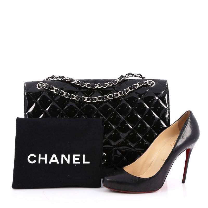 This authentic Chanel Classic Single Flap Bag Quilted Patent Maxi exudes a classic yet easy style made for the modern woman. Crafted from black patent leather, this elegant flap features Chanel's signature diamond quilted design, woven-in leather