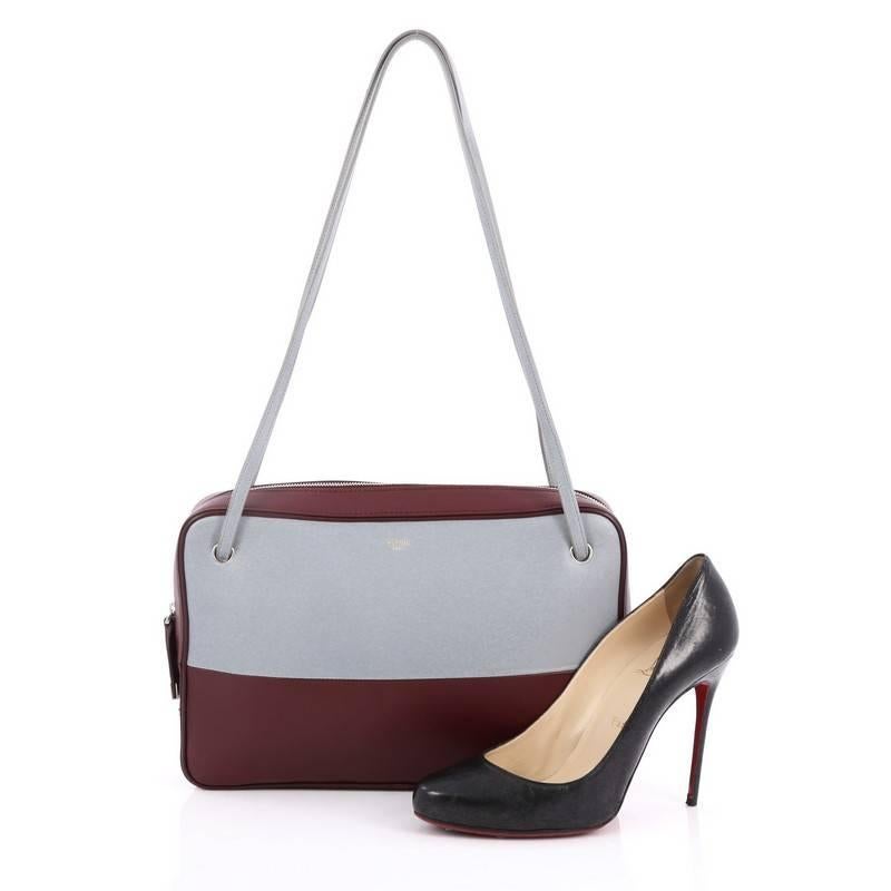 This authentic Celine Bicolor Side Lock Bag Leather Medium presented in the brand's 2013 Collection perfect for the modern fashionista. Crafted from bicolor burgundy and light blue leather, this chic bag featured dual fat shoulder straps, exterior