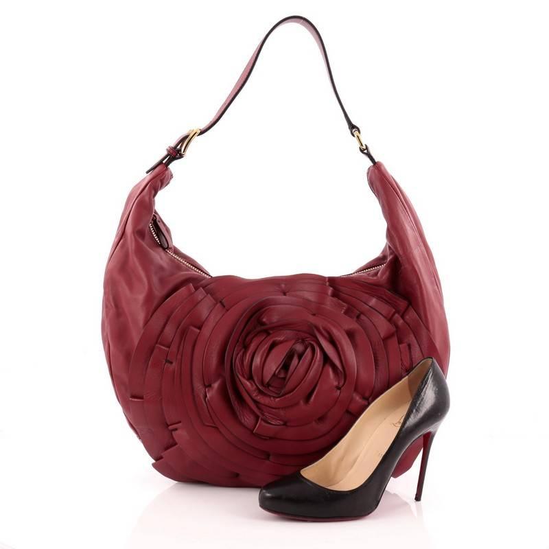 This authentic Valentino Petale Shoulder Bag Leather stylishly combines a casual silhouette with romantic motifs characteristic of Valentino's designs. Crafted from supple rouge red leather, this feminine bag features adjustable buckled shoulder