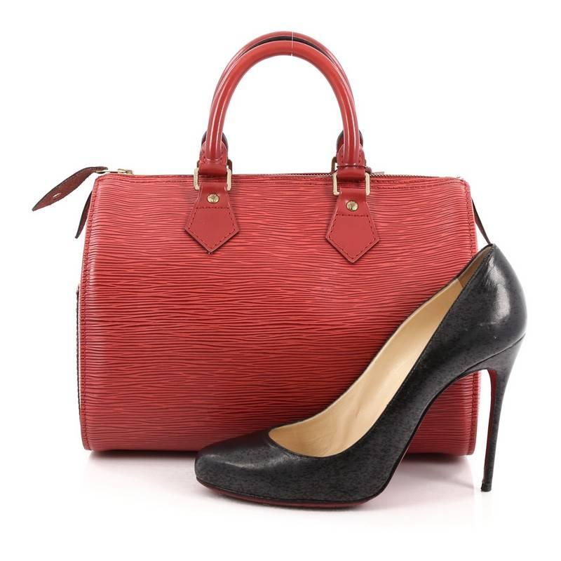 This authentic Louis Vuitton Speedy Handbag Epi Leather 25 is a timeless favorite of many. Crafted in red epi leather, this bag features dual-rolled handles, subtle stamped LV logo, exterior side slip pocket and gold-tone hardware accents. Its top