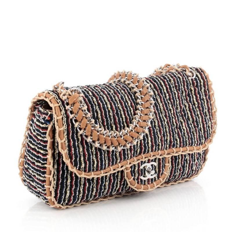 This authentic Chanel St. Tropez Flap Bag Tweed Large is a stylish and chic bag perfect for your daily excursions. Crafted from black and multi-color tweed, this bag features tan jute and leather woven trims and shoulder strap, front flap with CC