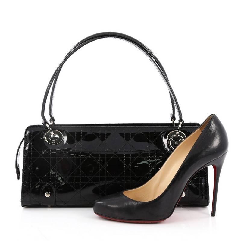 This authentic Christian Dior East West Lady Dior Handbag Stitched Cannage Patent Small is a classic and chic bag ideal for your nights out. Crafted from black stitched cannage patent leather, this luxurious handbag features dual flat patent leather