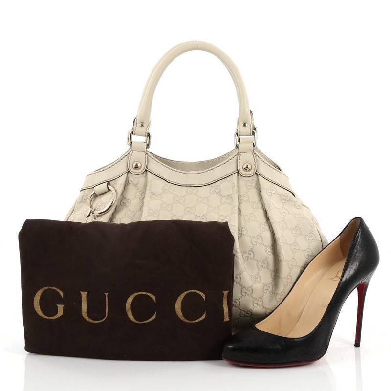 This authentic Gucci Sukey Tote Guccissima Leather Medium is a chic tote ideal for your everyday wear. Crafted from off-white guccissima leather, this pleated tote with a ring charm accent features dual-rolled leather top handles, side snap buttons,