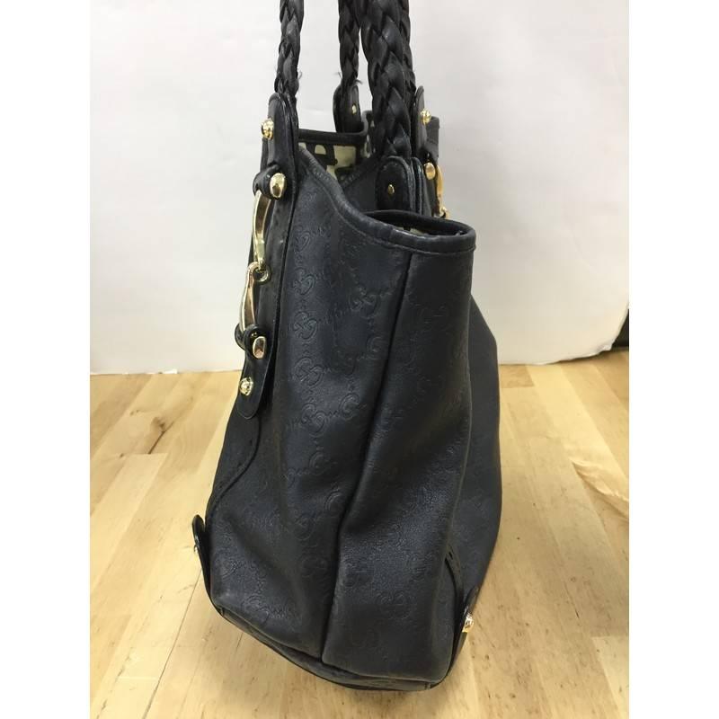 This authentic Gucci Pelham Shoulder Bag Guccissima Leather Medium is perfect for everyday use. Crafted in black guccissima embossed leather, this shoulder bag features braided leather shoulder straps, signature horsebit details, protective base