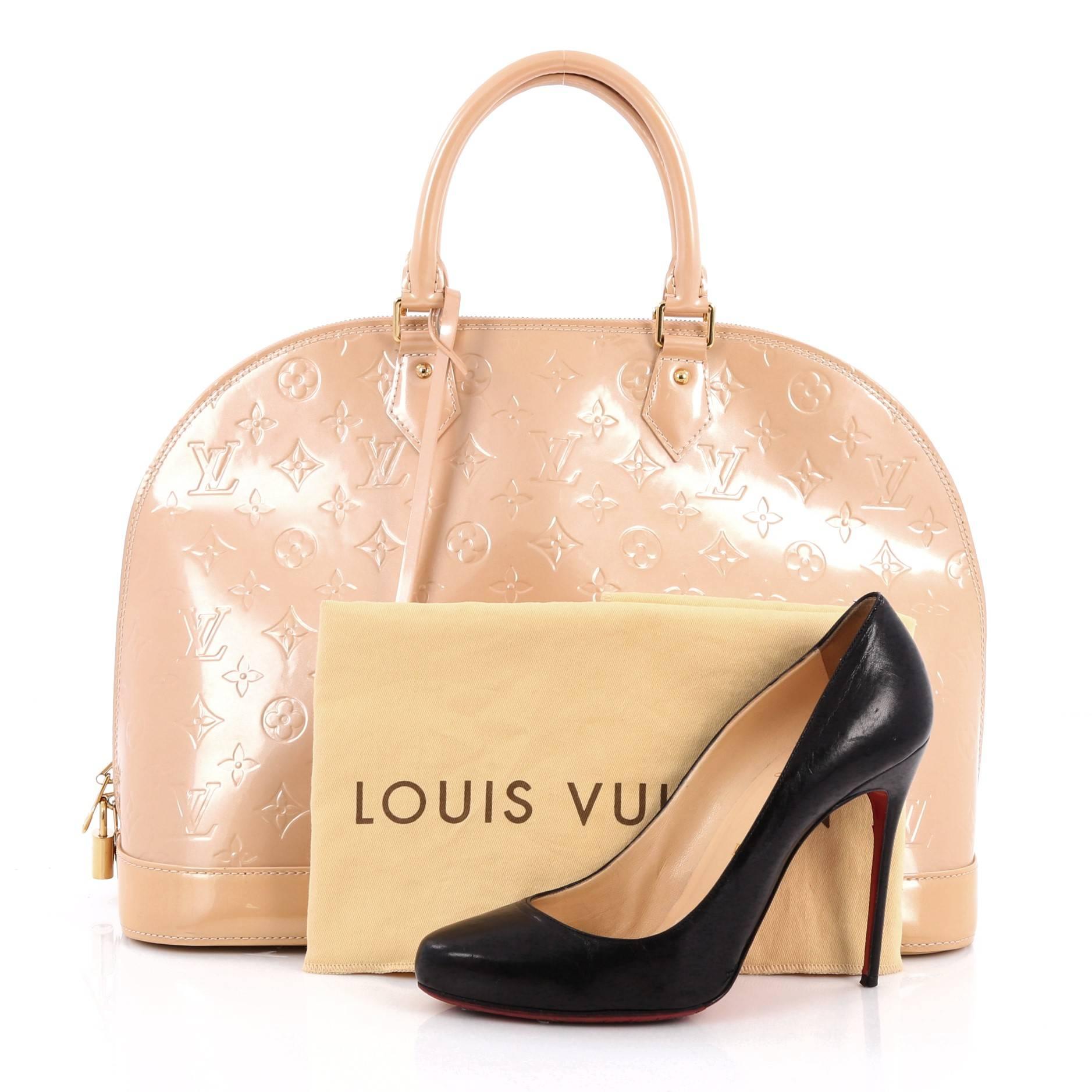 This authentic Louis Vuitton Alma Handbag Monogram Vernis GM is a fresh and elegant spin on a classic style that is perfect for all seasons. Crafted from Louis Vuitton's beige monogram vernis leather, this dome-shaped satchel features dual-rolled